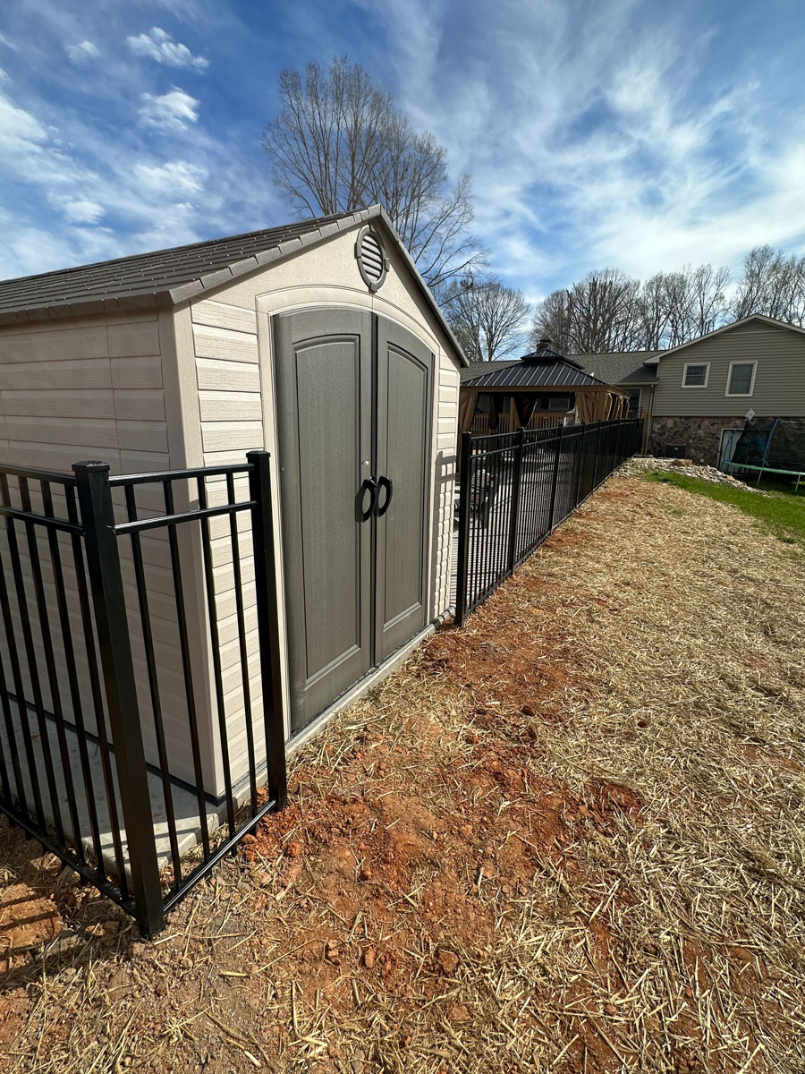black aluminum fence installed around an outdoor building to leave room for access to the building