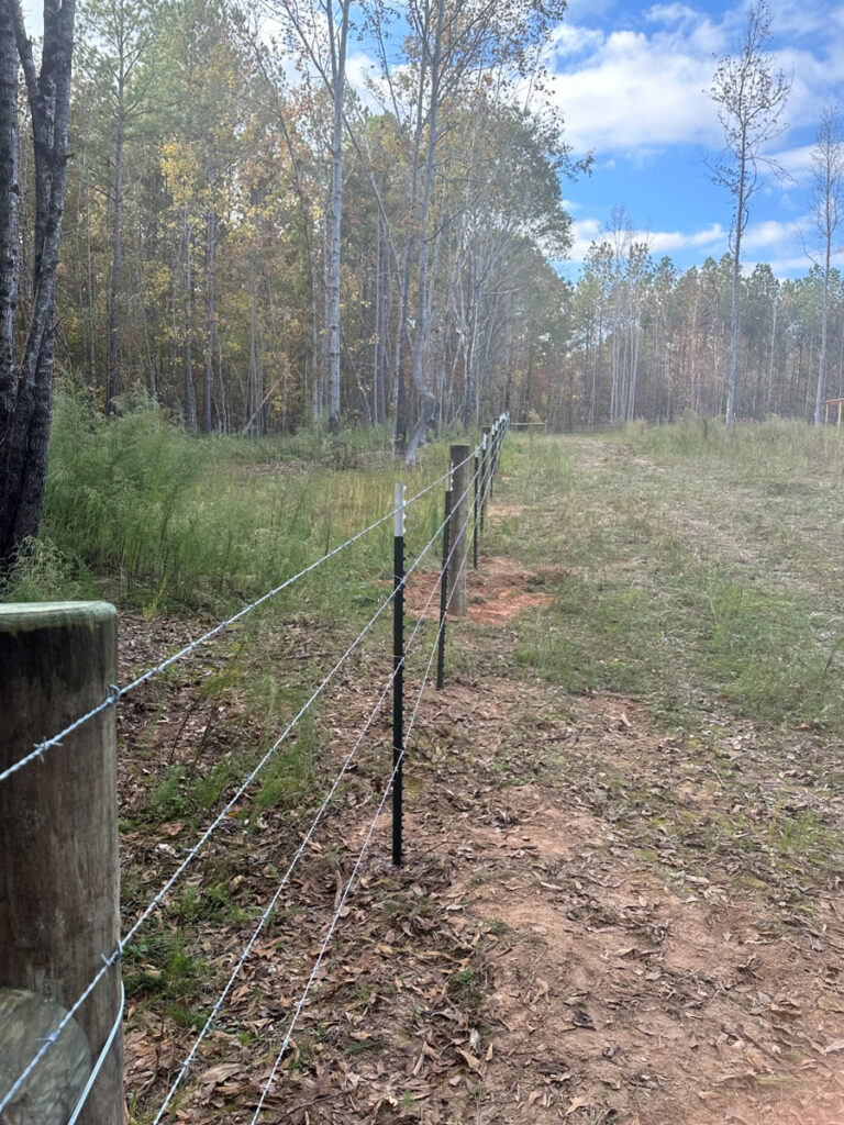 barbwire livestock fence installed with wood and t-posts